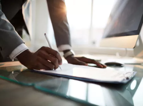 Close-up of Black Male Hands Writing at Desk