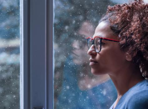 Black Person Looking Out Window on Rainy Day