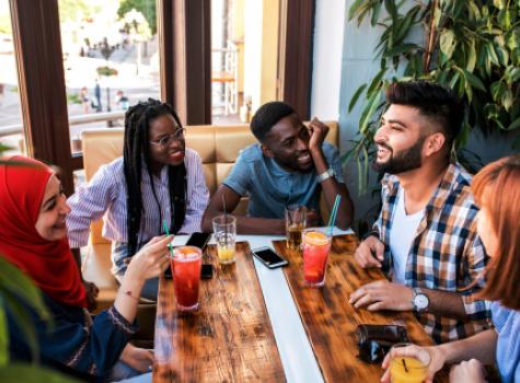 Smiling Group Interacting with Each Other at Table in a Restaurant