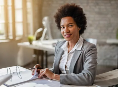 Professional Smiling at Camera While Working at Desk