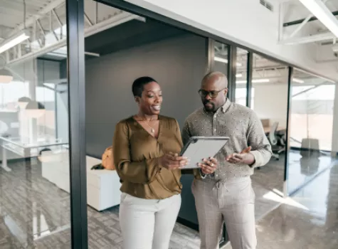 Businesspeople Collaborating Over Tablet In Office Setting