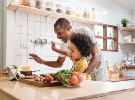 Father and Child Cooking in Kitchen and Waving at Tablet