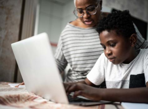 Black Male Child Working at a Laptop with an Adult