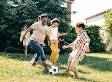 Group Playing Soccer in Yard During Summer