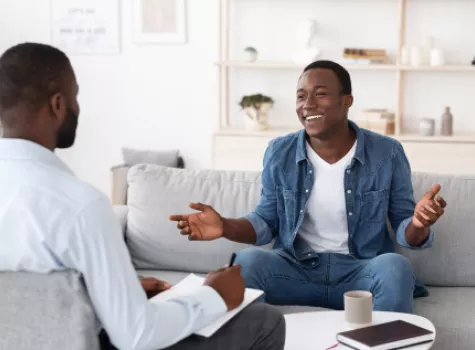 Two Black Men in Conversation and Taking Notes - Inside