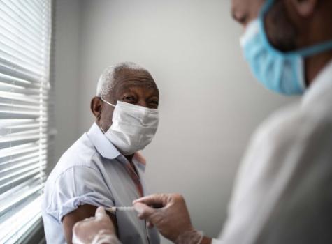 Black Man Getting a Shot From a Doctor