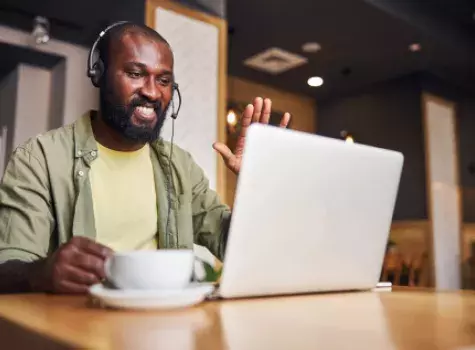 Black Man Wearing Headset on a Laptop Computer Meeting