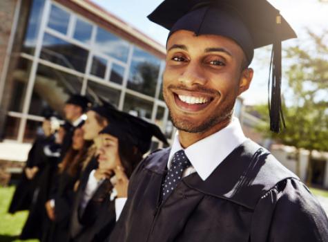 Close-up Male Graduate with Cap and Gown Smiling at Camera