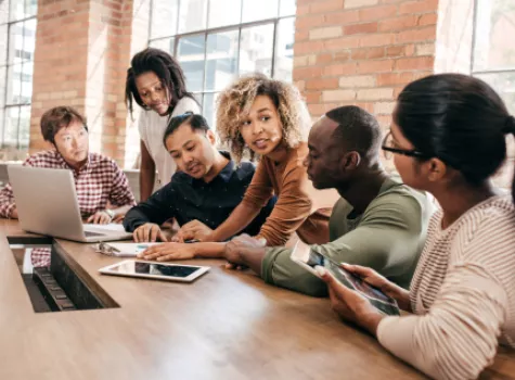 Group of People Gathered Around Conference Table and Laptop