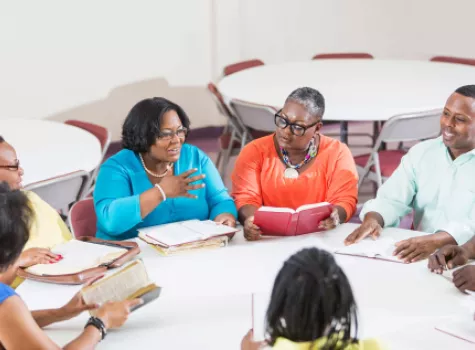 Group of Black Adults Conversing at a Round Table - Smiling