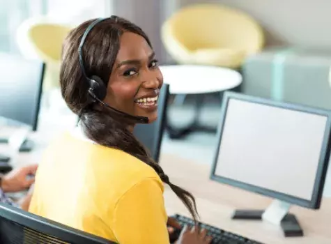 Black Female Professional Working on Computer and Smiling at Camera
