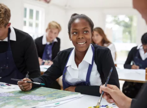 Young Black Female Student Smiling at Instructor During Art Class