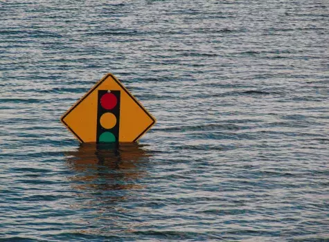 Yellow traffic sign partially submerged in floodwater