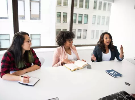 Three Young Females Working Together at an Office Table