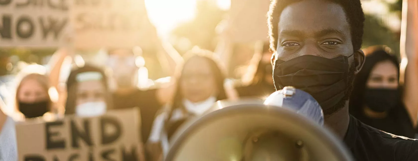 Black Male Standing with Protesters - Holding Megaphone